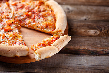 Image showing Delicious italian pizza with one eating piece