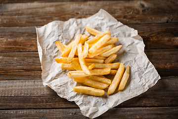 Image showing French fries on wooden table.