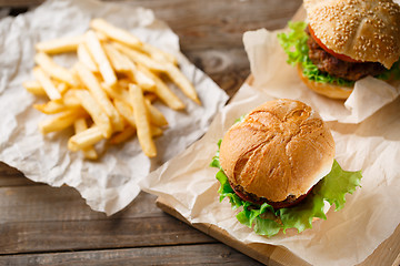 Image showing Homemade tasty burger and french fries on wooden table