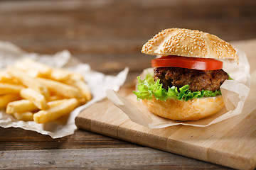 Image showing Homemade hamburgers and french fries on wooden table