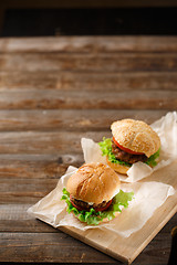 Image showing Homemade hamburgers and french fries on wooden table