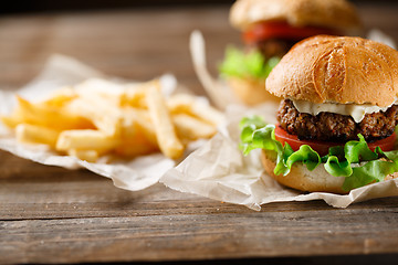 Image showing Homemade tasty burger and french fries on wooden table