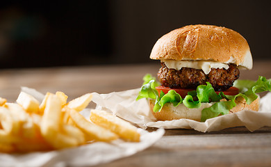 Image showing homemade burger and french fries on a wooden plate