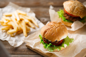 Image showing Homemade tasty burger and french fries on wooden table