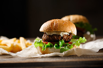 Image showing Homemade tasty burger and french fries on wooden table