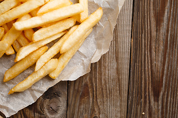 Image showing Fresh french fries on wooden background