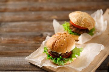 Image showing Homemade hamburgers and french fries on wooden table