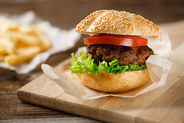 Image showing Homemade hamburgers and french fries on wooden table