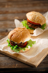 Image showing Homemade hamburgers and french fries on wooden table