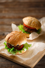 Image showing Homemade hamburgers and french fries on wooden table