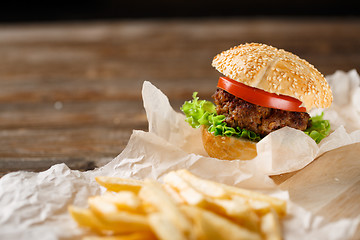 Image showing Homemade hamburgers and french fries on wooden table