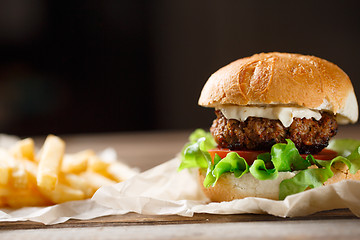 Image showing homemade burger and french fries on a wooden plate