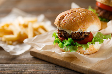 Image showing Homemade tasty burger and french fries on wooden table