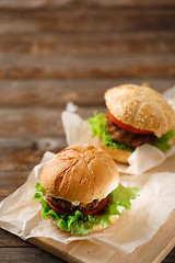 Image showing Homemade hamburgers and french fries on wooden table