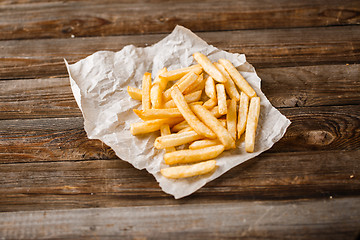 Image showing French fries on wooden table.