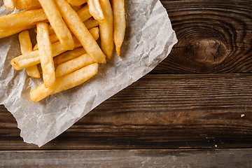 Image showing French fries on wooden table.