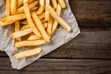 Image showing French fries on wooden table.