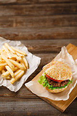 Image showing Homemade hamburgers and french fries on wooden table