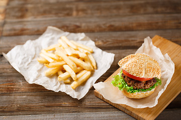 Image showing Homemade hamburgers and french fries on wooden table