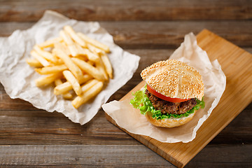 Image showing Homemade hamburgers and french fries on wooden table