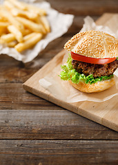 Image showing Homemade hamburgers and french fries on wooden table