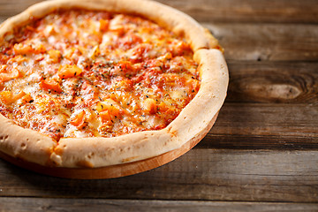 Image showing Tasty pizza on old wooden table.