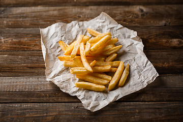 Image showing French fries on wooden table.