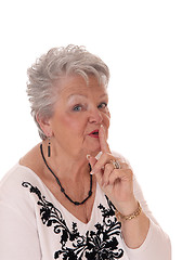 Image showing Senior woman with finger over mouth.