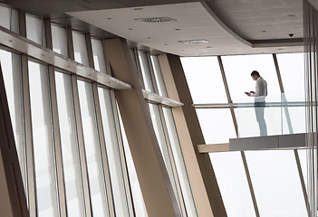 Image showing young successful business man in penthouse apartment working on 