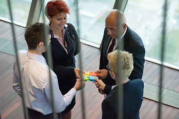Image showing top view of business people group assembling jigsaw puzzle