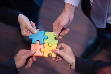 Image showing top view of business people group assembling jigsaw puzzle