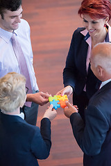 Image showing top view of business people group assembling jigsaw puzzle