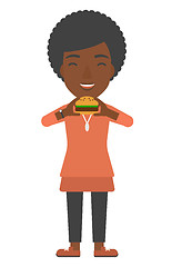 Image showing Woman eating hamburger. 