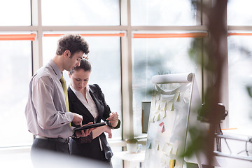 Image showing young couple working on flip board at office