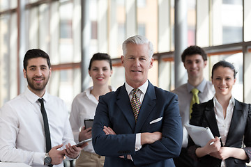 Image showing portrait of senior businessman as leader  with group of people i