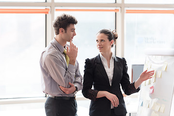 Image showing young couple working on flip board at office