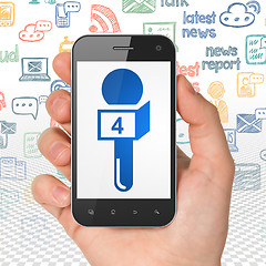 Image showing News concept: Hand Holding Smartphone with Microphone on display