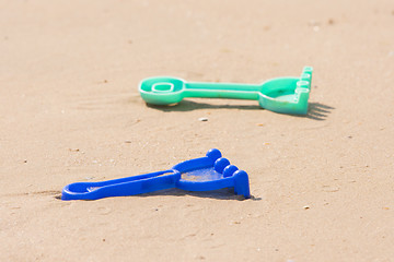 Image showing  Childrens toy rake lying on the sand