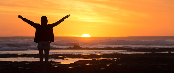 Image showing Free woman enjoying freedom on beach at sunset.