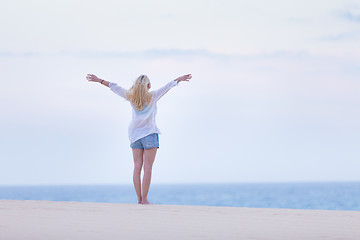 Image showing Free woman enjoying freedom on beach in morning.