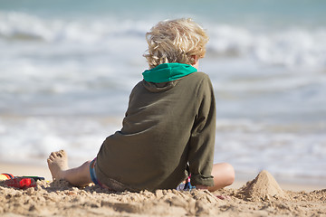 Image showing Boy playing with toys on beach.