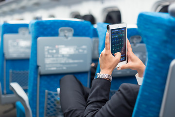 Image showing Businessman using tablet phone on airplane.