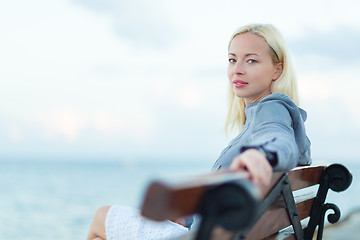 Image showing Lady sitting on a bench outdoors