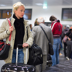 Image showing Female traveler transporting luggage in airport.