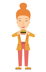 Image showing Woman eating hamburger. 