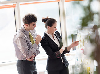 Image showing young couple working on flip board at office