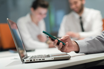 Image showing close up of  businessman hands  using smart phone on meeting