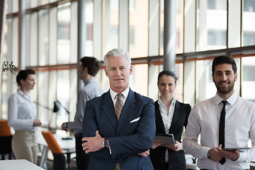 Image showing portrait of senior businessman as leader  with group of people i