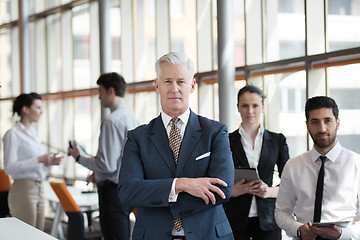 Image showing portrait of senior businessman as leader  with group of people i