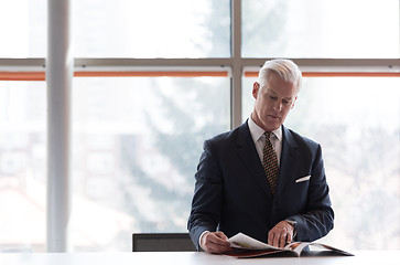 Image showing senior business man reading magazine